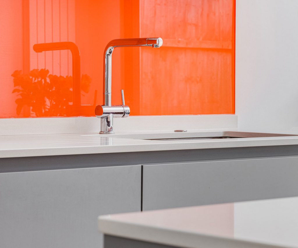 Handleless kitchen with orange splashback